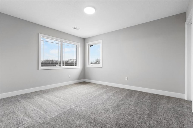 carpeted empty room featuring visible vents and baseboards