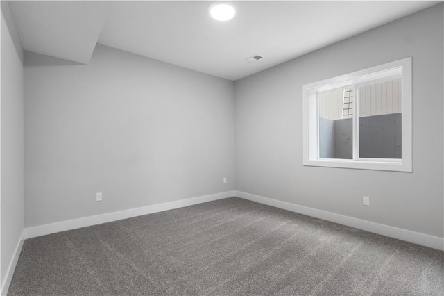 unfurnished room featuring carpet floors, visible vents, and baseboards