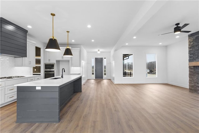 kitchen featuring a spacious island, light countertops, hanging light fixtures, appliances with stainless steel finishes, and open floor plan