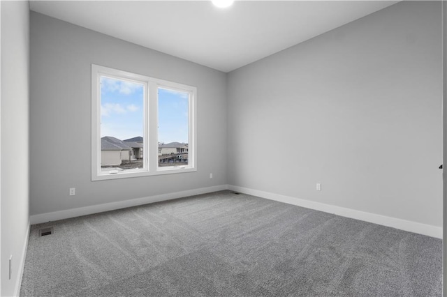 carpeted empty room with visible vents and baseboards