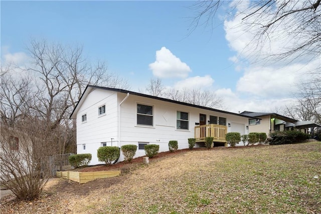 ranch-style house featuring a deck and a front lawn