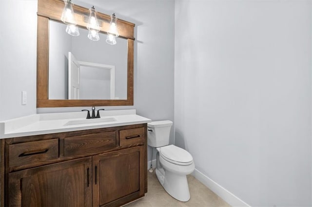 half bathroom with toilet, tile patterned flooring, baseboards, and vanity