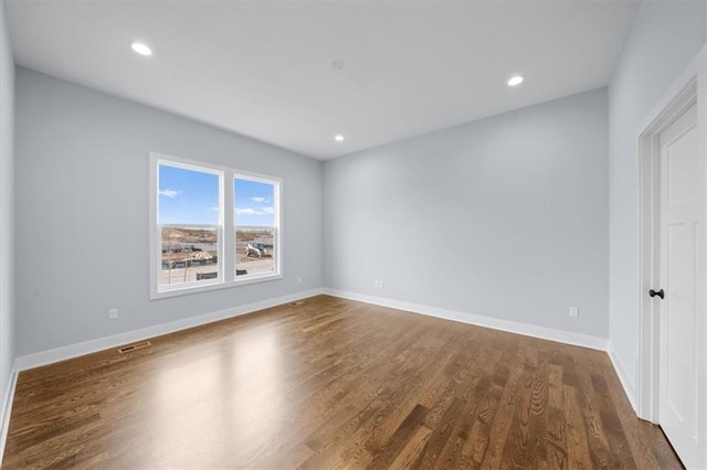 spare room with dark wood-style floors, recessed lighting, visible vents, and baseboards