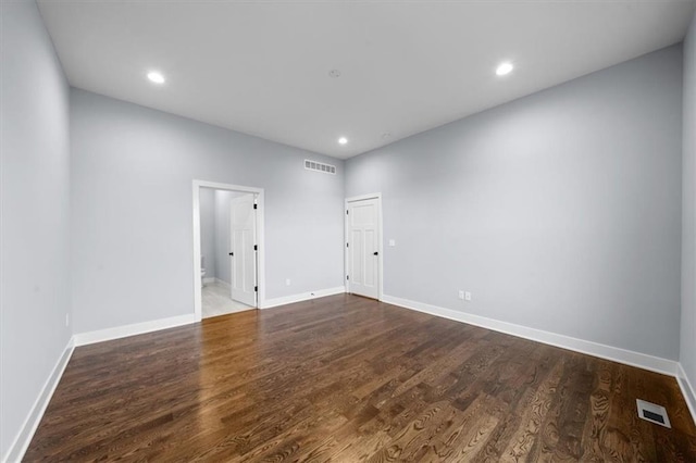 empty room with visible vents, baseboards, and wood finished floors