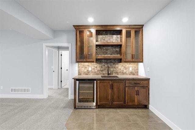 bar featuring visible vents, decorative backsplash, wine cooler, wet bar, and a sink