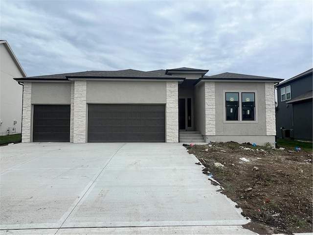 1708 SW Arbormist Dr, Lees Summit, MO 64082 - prairie-style home featuring an attached garage, concrete driveway, stone siding, and stucco siding