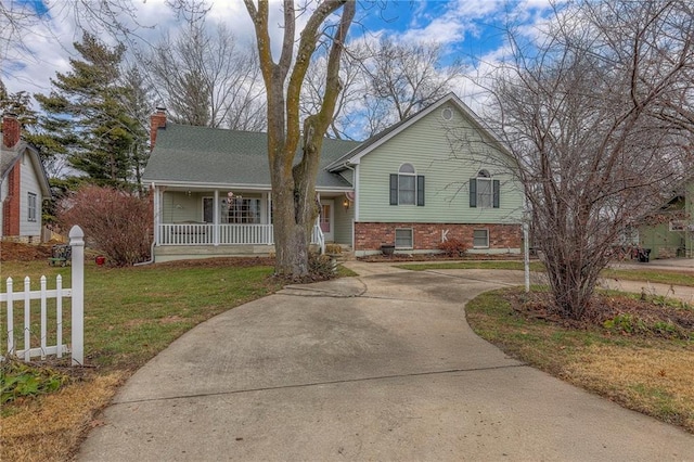 tri-level home featuring covered porch and a front yard