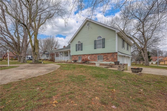 view of front of property with a garage, covered porch, and a front lawn