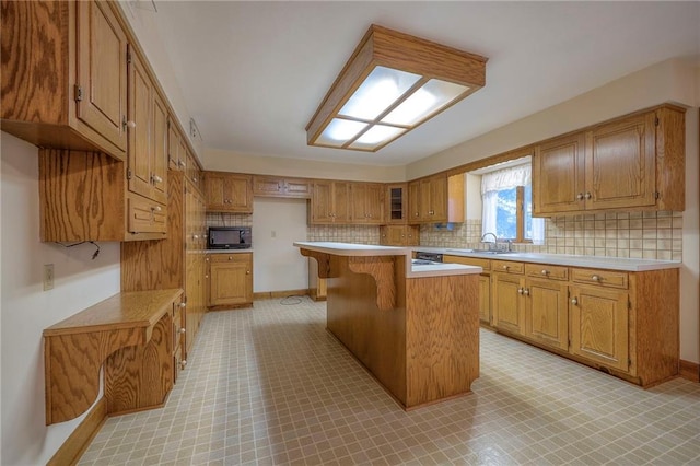 kitchen featuring a kitchen island, sink, and a breakfast bar area