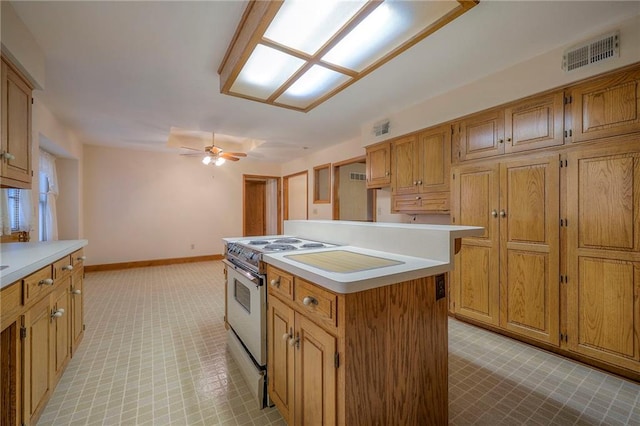 kitchen with electric range, a center island, and ceiling fan