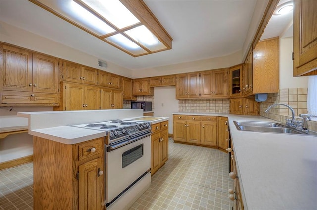 kitchen with white range oven, backsplash, sink, and a kitchen island