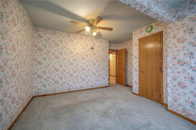 carpeted spare room with ceiling fan