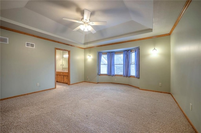 carpeted empty room with crown molding, ceiling fan, and a tray ceiling