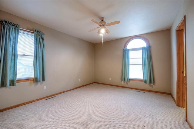 carpeted spare room featuring ceiling fan