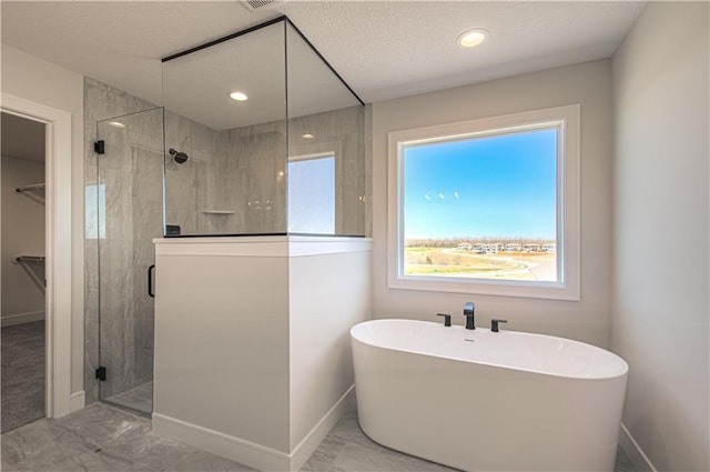 bathroom featuring a freestanding bath, marble finish floor, a shower stall, and baseboards