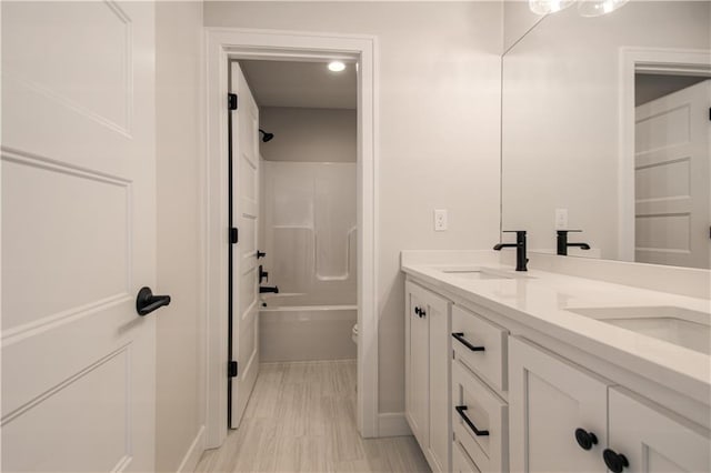 full bathroom with  shower combination, a sink, toilet, and double vanity