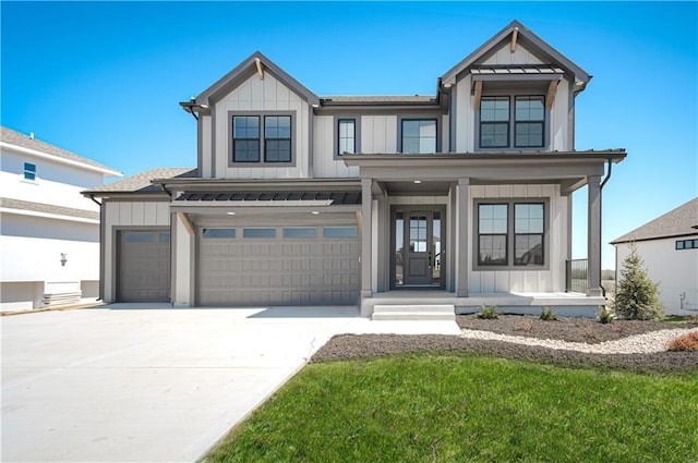 modern farmhouse featuring concrete driveway, an attached garage, a porch, board and batten siding, and a front yard