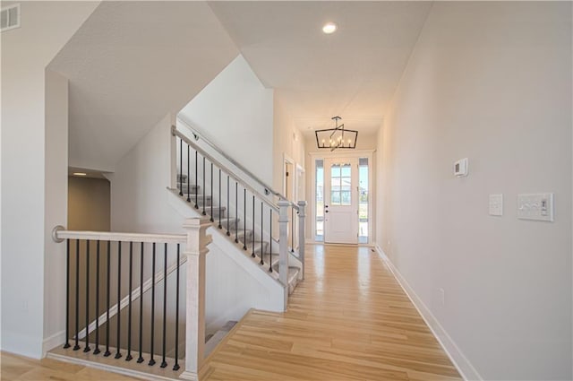 foyer with a notable chandelier, recessed lighting, visible vents, light wood-style floors, and baseboards