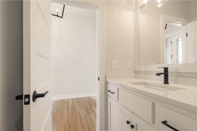 bathroom with vanity, baseboards, and wood finished floors