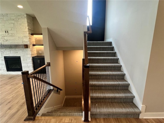 1712 SW Arbormist Dr, Lees Summit, MO 64082 - staircase featuring wood finished floors and a stone fireplace