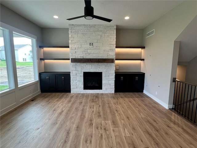 1712 SW Arbormist Dr, Lees Summit, MO 64082 - unfurnished living room featuring ceiling fan, wood finished floors, a stone fireplace, and recessed lighting