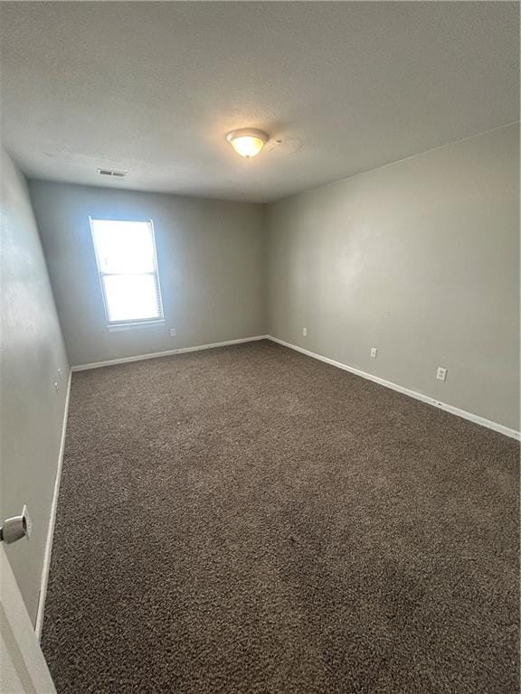 unfurnished room with dark carpet