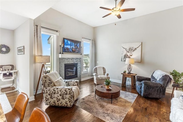 living room featuring a fireplace, ceiling fan, and dark hardwood / wood-style floors