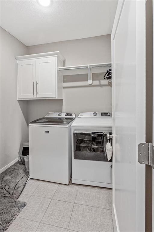 laundry area with washing machine and dryer and cabinets