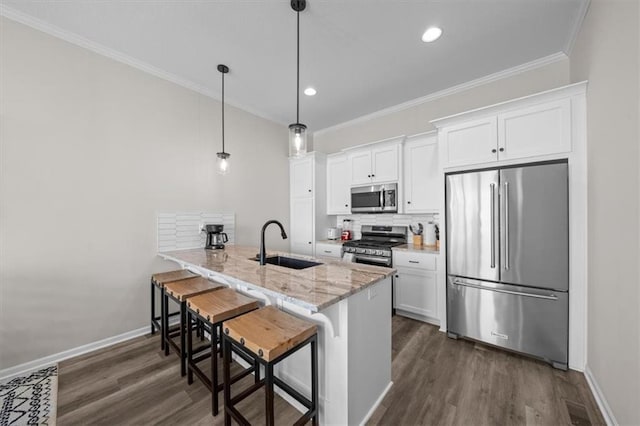 kitchen with sink, stainless steel appliances, white cabinets, a kitchen bar, and kitchen peninsula