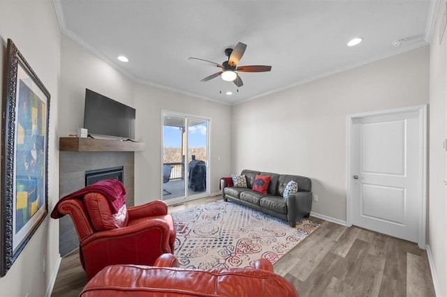 living room with ceiling fan, ornamental molding, and light hardwood / wood-style floors