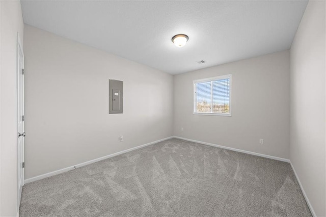 empty room featuring light carpet and electric panel