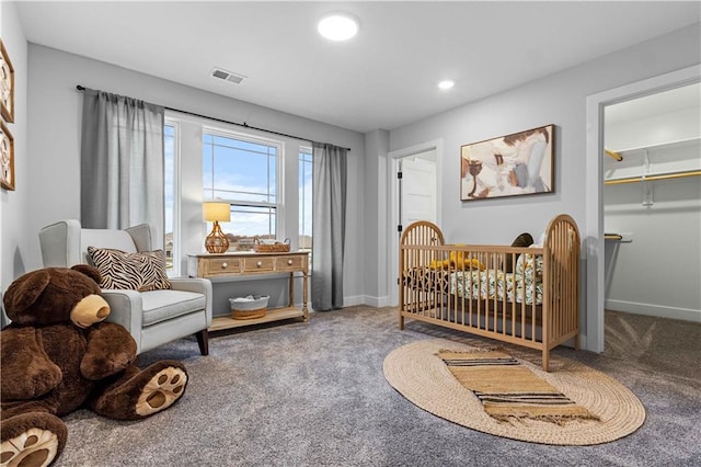 bedroom with carpet, a spacious closet, and a nursery area