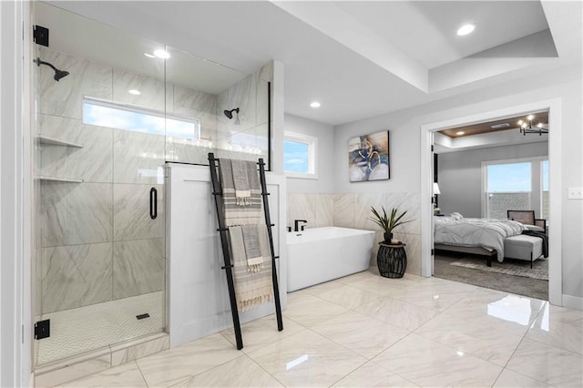 bathroom featuring independent shower and bath and an inviting chandelier