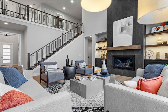 living room featuring hardwood / wood-style floors, a towering ceiling, and a fireplace