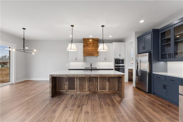 kitchen with white cabinetry, glass insert cabinets, stainless steel appliances, and light countertops