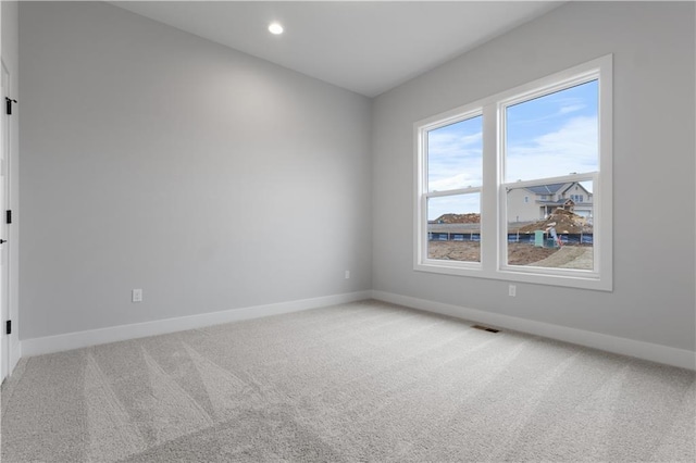 spare room featuring recessed lighting, carpet flooring, visible vents, and baseboards