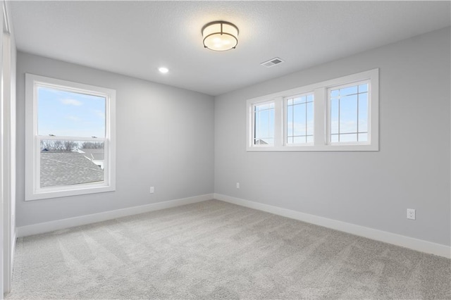 spare room with baseboards, recessed lighting, visible vents, and light colored carpet