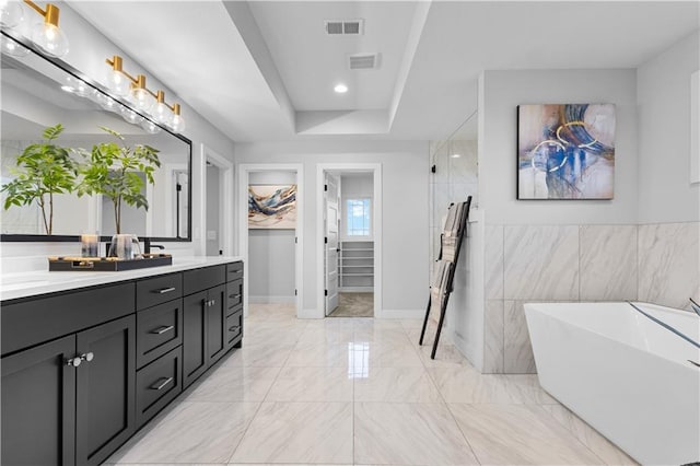 bathroom featuring visible vents, a freestanding bath, double vanity, tiled shower, and marble finish floor