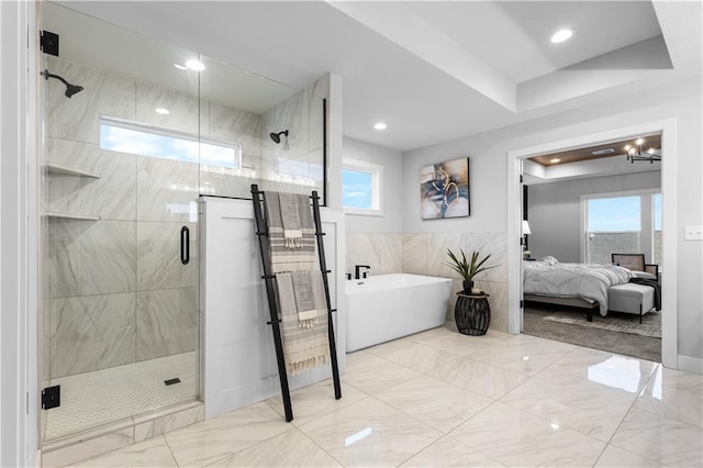 ensuite bathroom featuring connected bathroom, a shower stall, a freestanding bath, recessed lighting, and marble finish floor