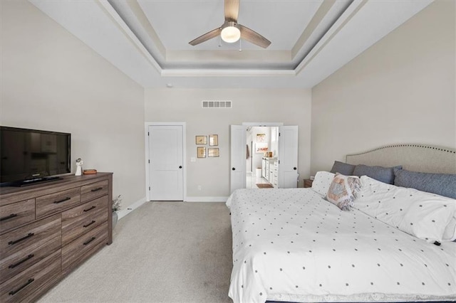 bedroom featuring a raised ceiling, a towering ceiling, light colored carpet, and ceiling fan