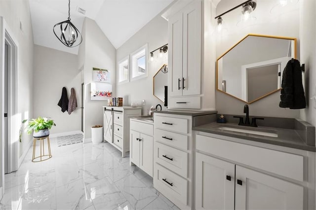 bathroom featuring an inviting chandelier, lofted ceiling, and vanity