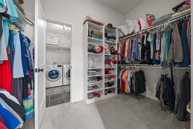 spacious closet featuring separate washer and dryer and carpet flooring