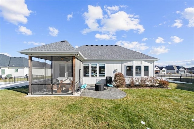 rear view of house featuring ceiling fan, a yard, a patio area, and a sunroom