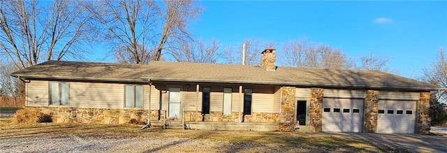 ranch-style home with driveway, stone siding, a chimney, and an attached garage