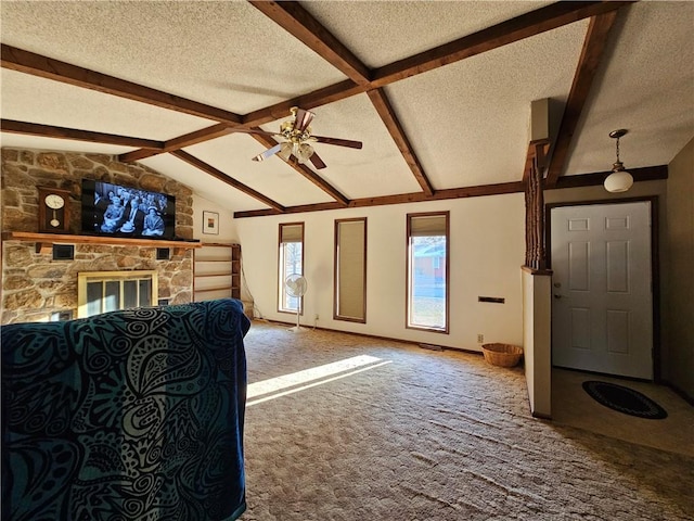 unfurnished living room featuring carpet flooring, vaulted ceiling with beams, a stone fireplace, and a textured ceiling