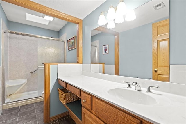 bathroom featuring a shower with door, vanity, tile patterned floors, and toilet