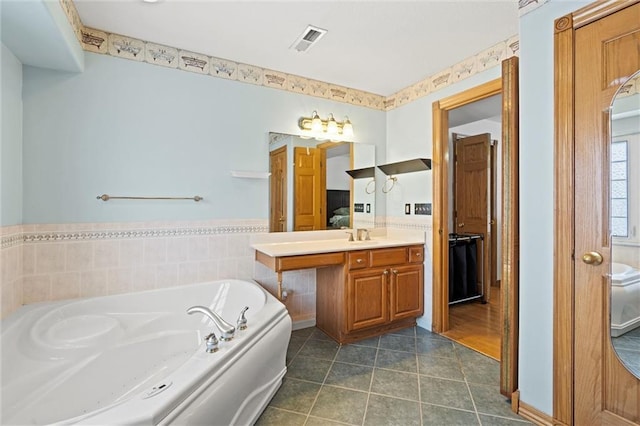 bathroom featuring a washtub, vanity, and tile patterned floors