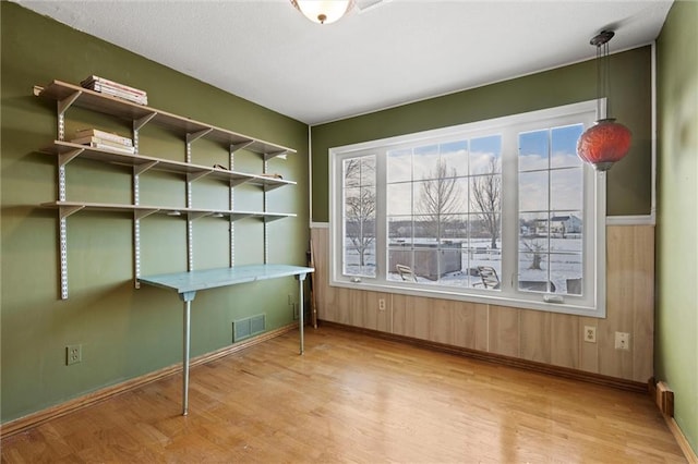 misc room featuring wood walls and light hardwood / wood-style floors