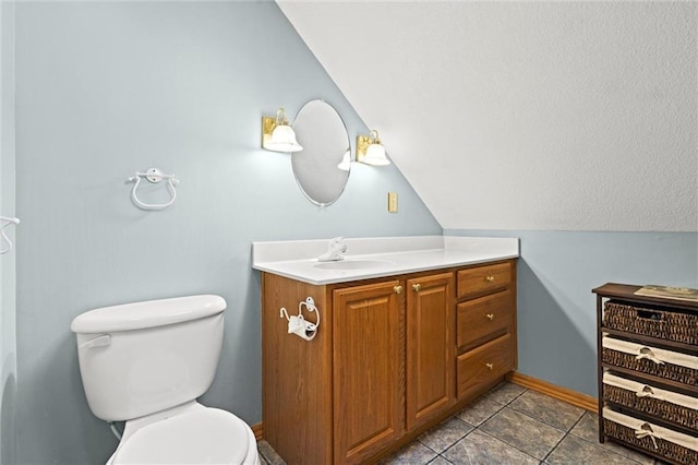 bathroom with vaulted ceiling, vanity, and toilet