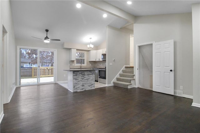 unfurnished living room featuring vaulted ceiling with beams, sink, dark hardwood / wood-style floors, and ceiling fan with notable chandelier